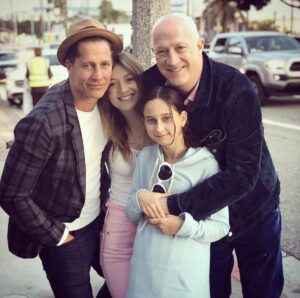 A Family Photo of Billie With Her Two Dads, Bryan and Bruce and her Sister, Ava.